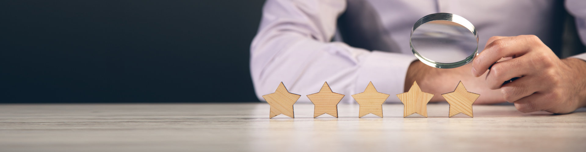 man looking at wooden stars with magnifier