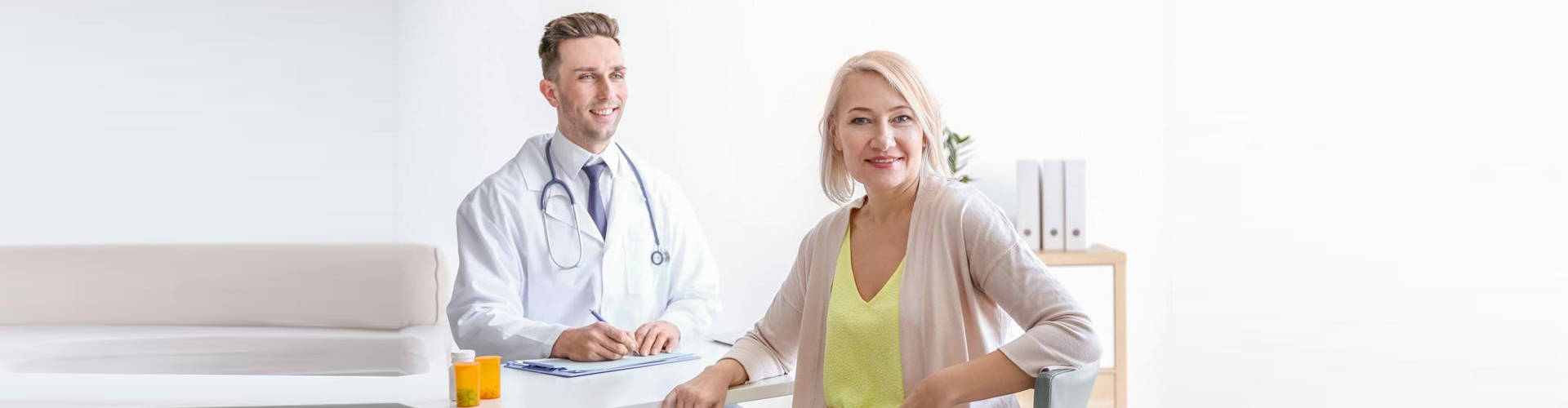 doctor writing while looking at the senior woman