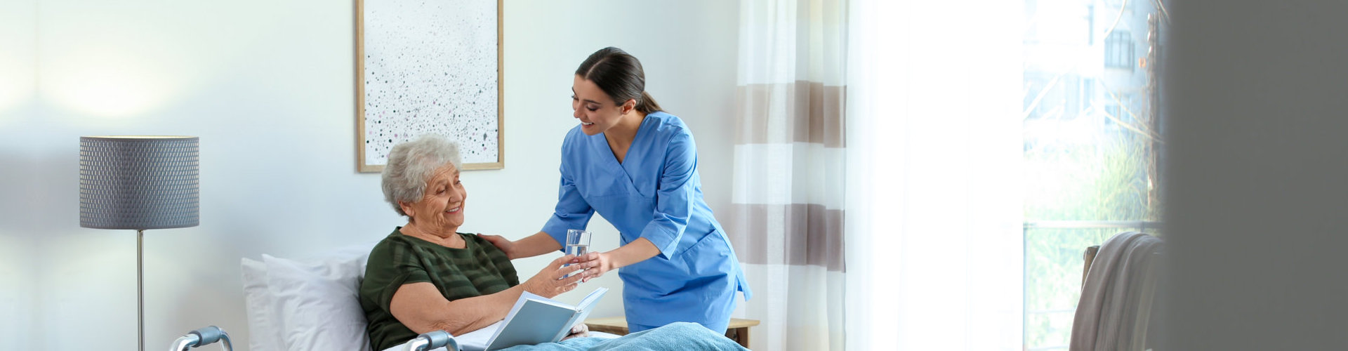 caregiver giving water to senior woman